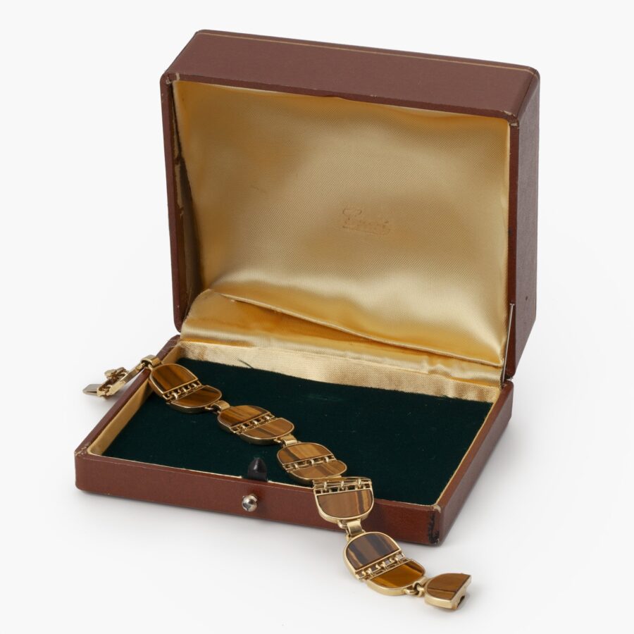 Achttien karaat geelgouden armband bezet met tijgeroog, gesigneerd Gucci, ca 1970