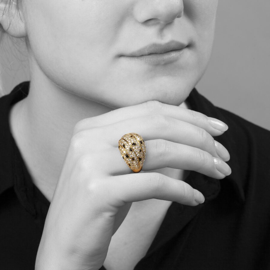 Een achttien karaat geelgouden ring, pavé bezet met briljant geslepen diamanten en onyx. Gesigneerd Cartier Paris, vervaardigd omstreeks 1995 en genummerd.