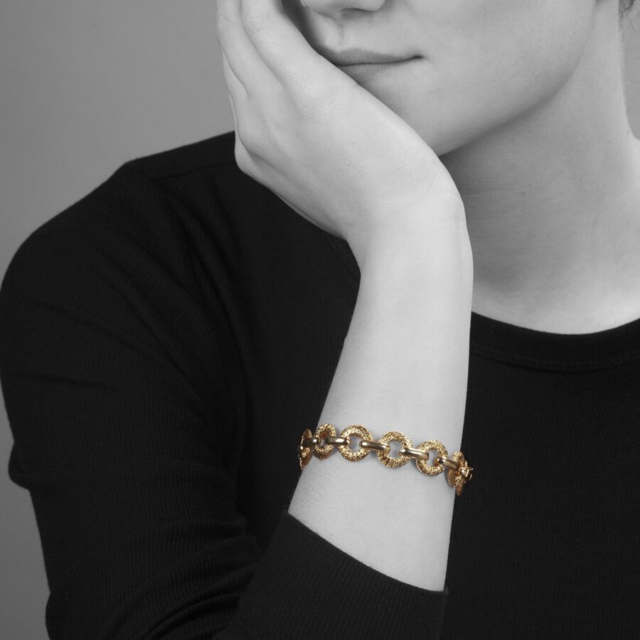 Een achttien karaat geelgouden armband bestaande uit dertien van gouddraad geweven schakels. Gesigneerd Fred, vervaardigd ca 1970 door Georges Lenfant.
