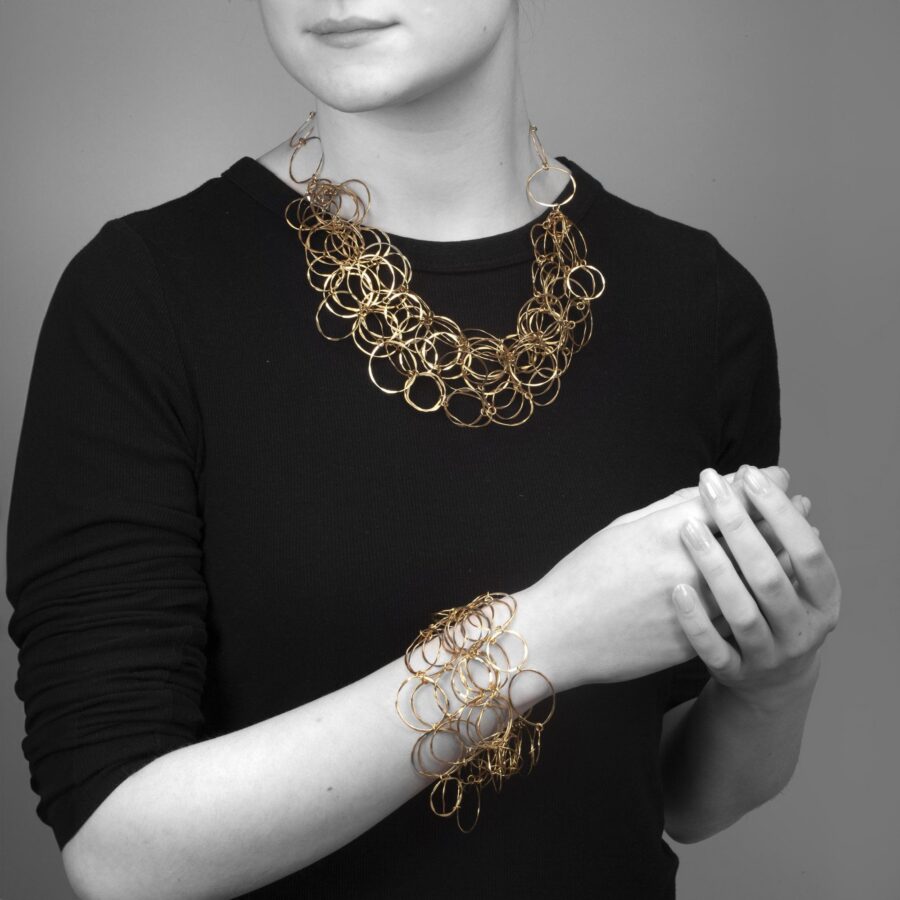 Een achttien karaat geelgouden collier en bijpassende armband bestaande uit vele ringen. Gesigneerd Cartier en genummerd. Vervaardigd omstreeks 1980.