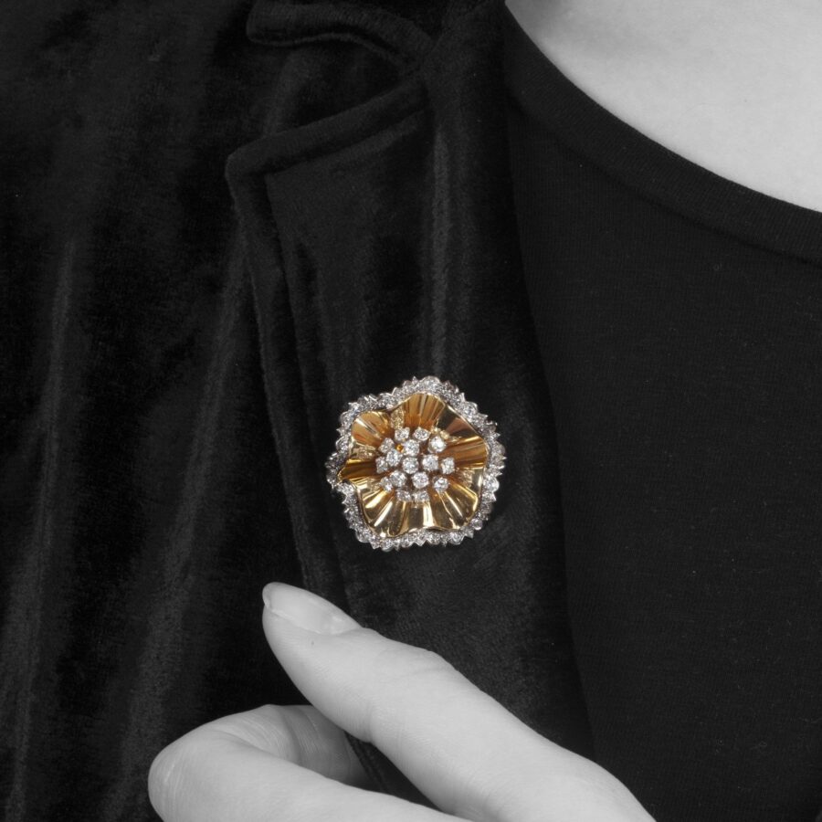 Een achttien karaat geelgoud en platina broche in de vorm van een rozet, deels bezet met diamanten. Gesigneerd Van Cleef & Arpels, Parijs,1947.