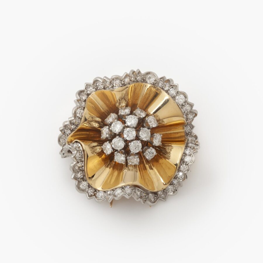 Een achttien karaat geelgoud en platina broche in de vorm van een rozet, deels bezet met diamanten. Gesigneerd Van Cleef & Arpels, Parijs,1947.