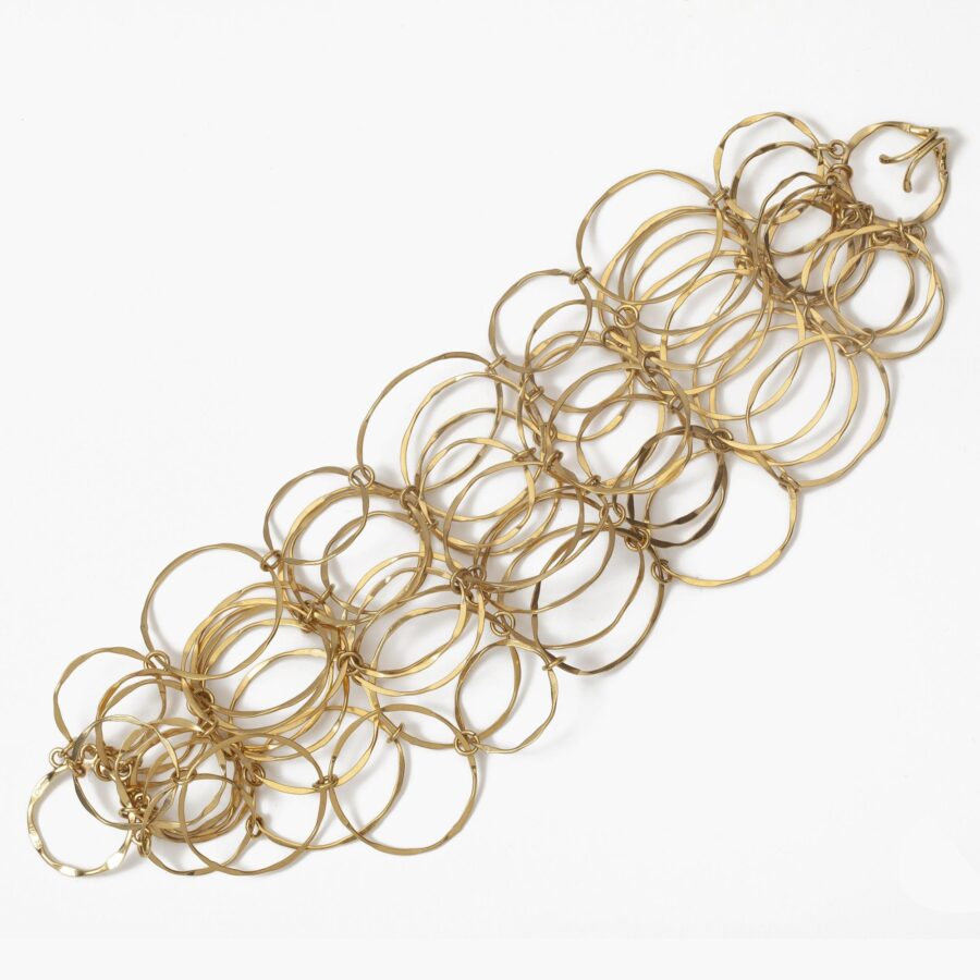 Een achttien karaat geelgouden collier en bijpassende armband bestaande uit vele ringen. Gesigneerd Cartier en genummerd. Vervaardigd omstreeks 1980.