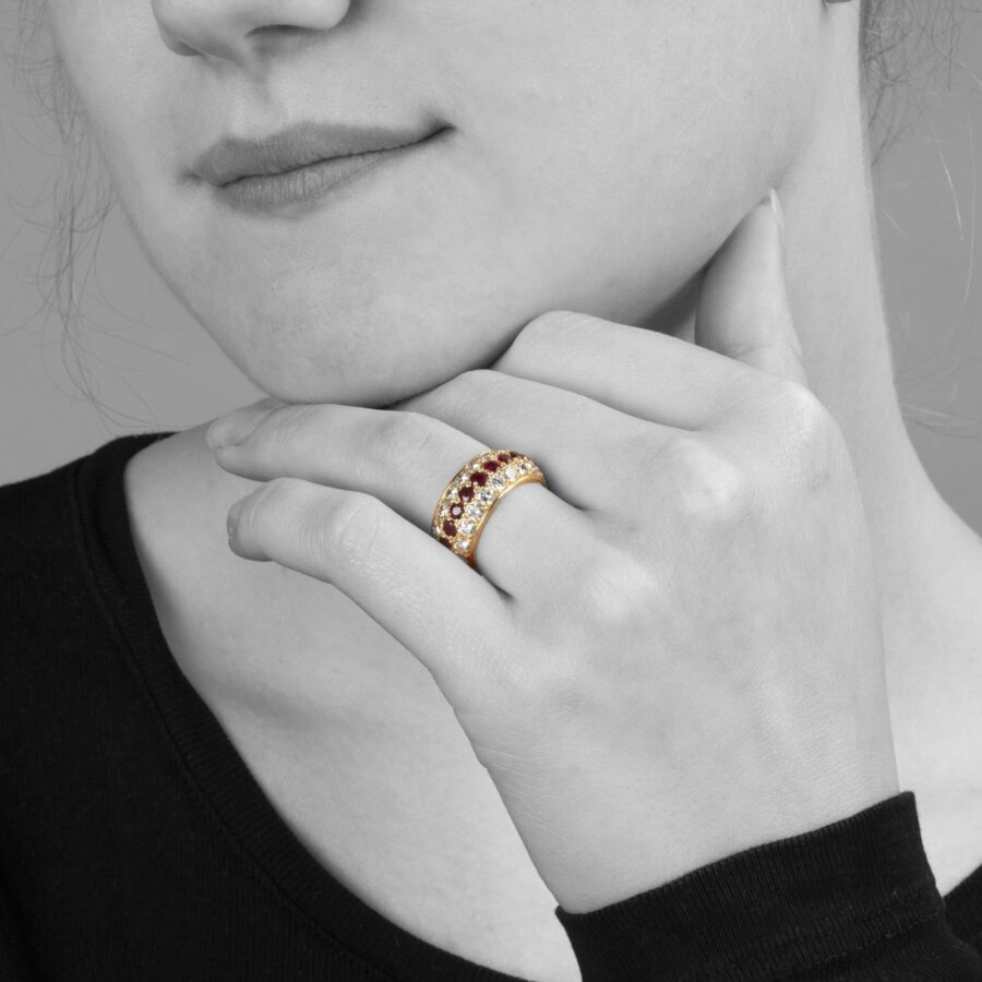 Een achttien karaat geelgouden volle alliance-ring, bezet met robijnen en diamanten. Van Cleef & Arpels, Parijs. Met origineel etui en pouch.