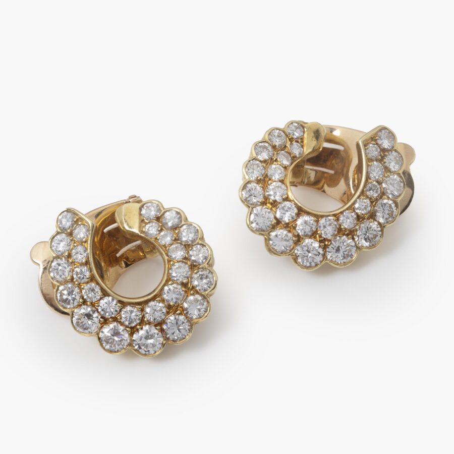 Een paar achttien karaat geelgouden oorclips, geheel pavé bezet met briljant geslepen diamanten. Gesigneerd Van Cleef & Arpels, Parijs, omstreeks 1980. 