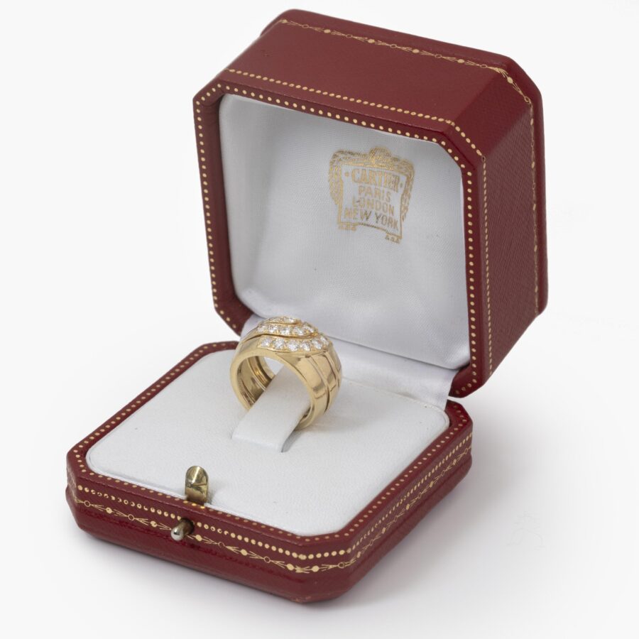Een achttien karaat geelgouden bandring deels pavé gezet met briljant geslepen diamanten. Gesigneerd Cartier London, 1989 en genummerd. Met origineel etui.