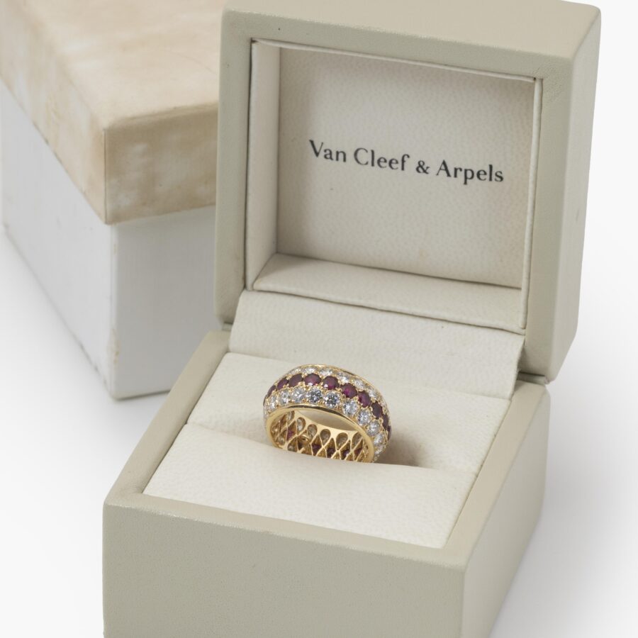 Een achttien karaat geelgouden volle alliance-ring, bezet met robijnen en diamanten. Van Cleef & Arpels, Parijs. Met origineel etui en pouch.