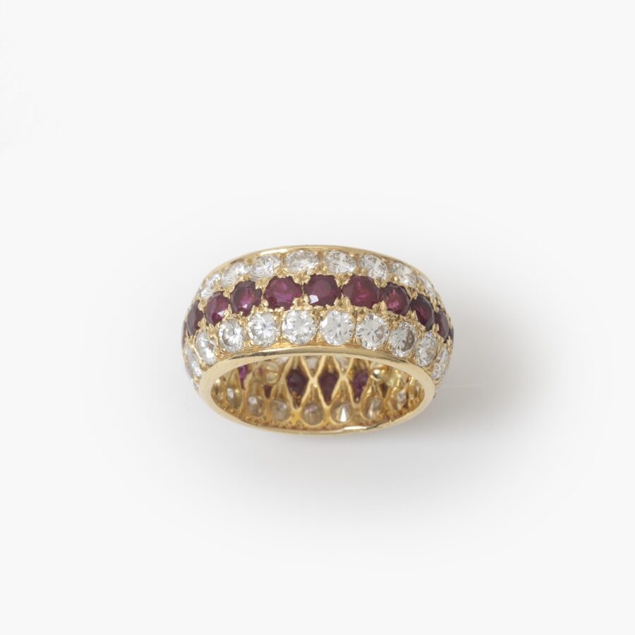 Een achttien karaat geelgouden volle alliance-ring, bezet met robijnen en diamanten. Van Cleef & Arpels, Parijs. Met origineel etui en pouch.