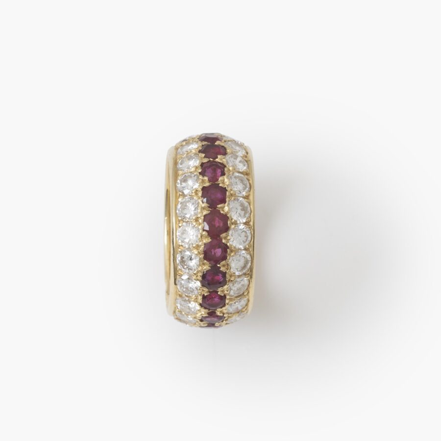 Een achttien karaat geelgouden volle alliance-ring, bezet met robijnen en diamanten. Van Cleef & Arpels, Parijs. Met origineel etui en pouch.