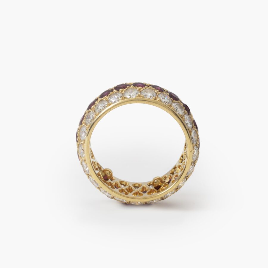 Een achttien karaat geelgouden volle alliance-ring, bezet met robijnen en diamanten. Van Cleef & Arpels, Parijs. Met origineel etui en pouch.