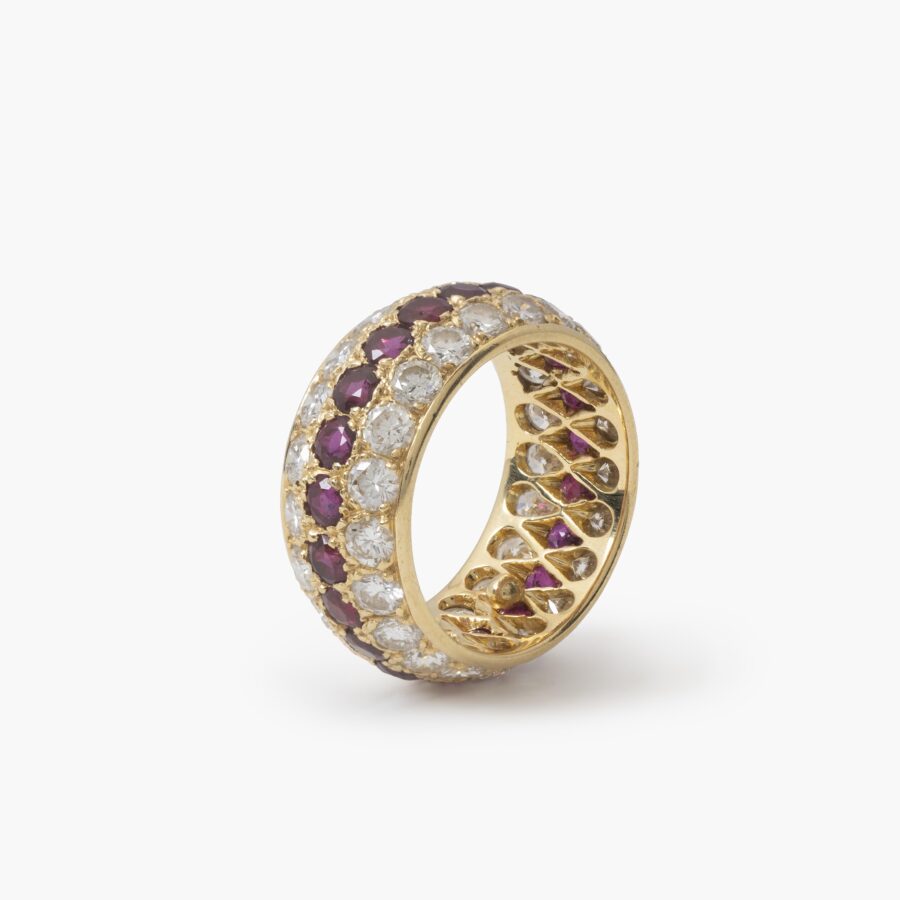 Een achttien karaat geelgouden volle alliance-ring, bezet met robijnen en diamanten. Van Cleef & Arpels, Parijs. Met origineel etui en pouch.