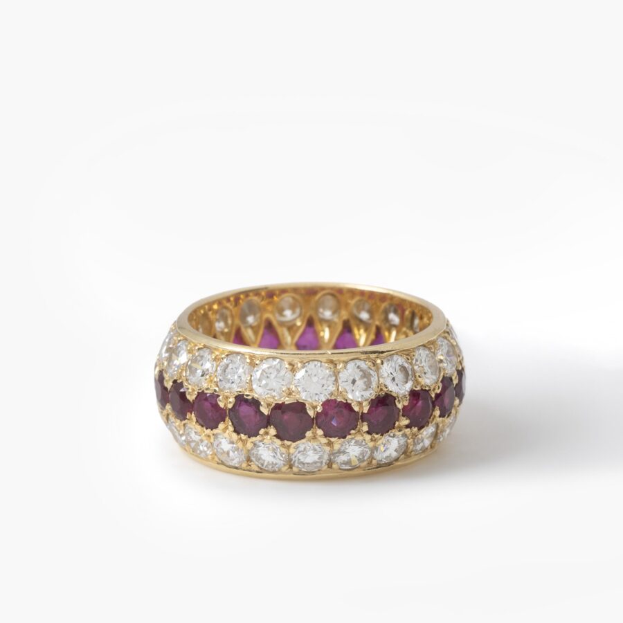 Een achttien karaat geelgouden volle alliance-ring, bezet met robijnen en diamanten. Van Cleef & Arpels, Parijs. Met origineel etui en pouch.