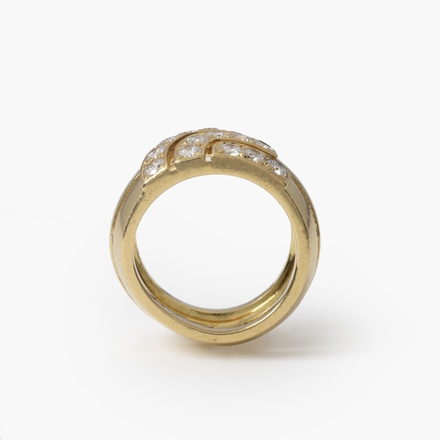 Een achttien karaat geelgouden bandring deels pavé gezet met briljant geslepen diamanten. Gesigneerd Cartier London, 1989 en genummerd. Met origineel etui.