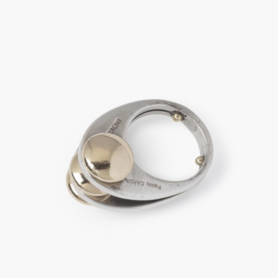 Een eerste gehalte zilveren ring met drie discusvormige veertien karaat geelgouden knoppen. Gesigneerd Pierre Cardin, vervaardigd omstreeks 1965.