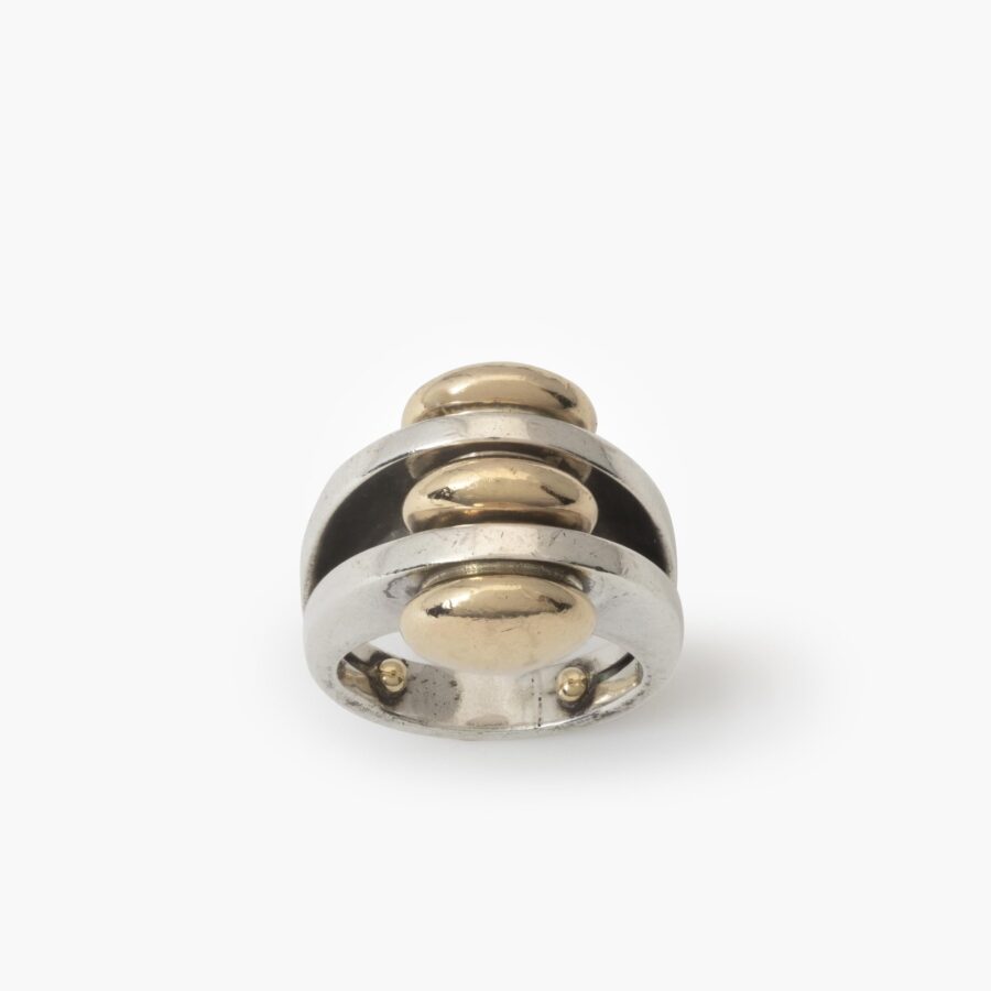 Een eerste gehalte zilveren ring met drie discusvormige veertien karaat geelgouden knoppen. Gesigneerd Pierre Cardin, vervaardigd omstreeks 1965.