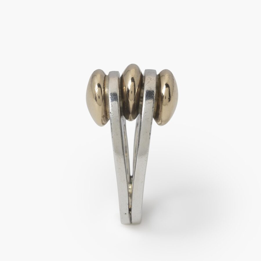 Een eerste gehalte zilveren ring met drie discusvormige veertien karaat geelgouden knoppen. Gesigneerd Pierre Cardin, vervaardigd omstreeks 1965.
