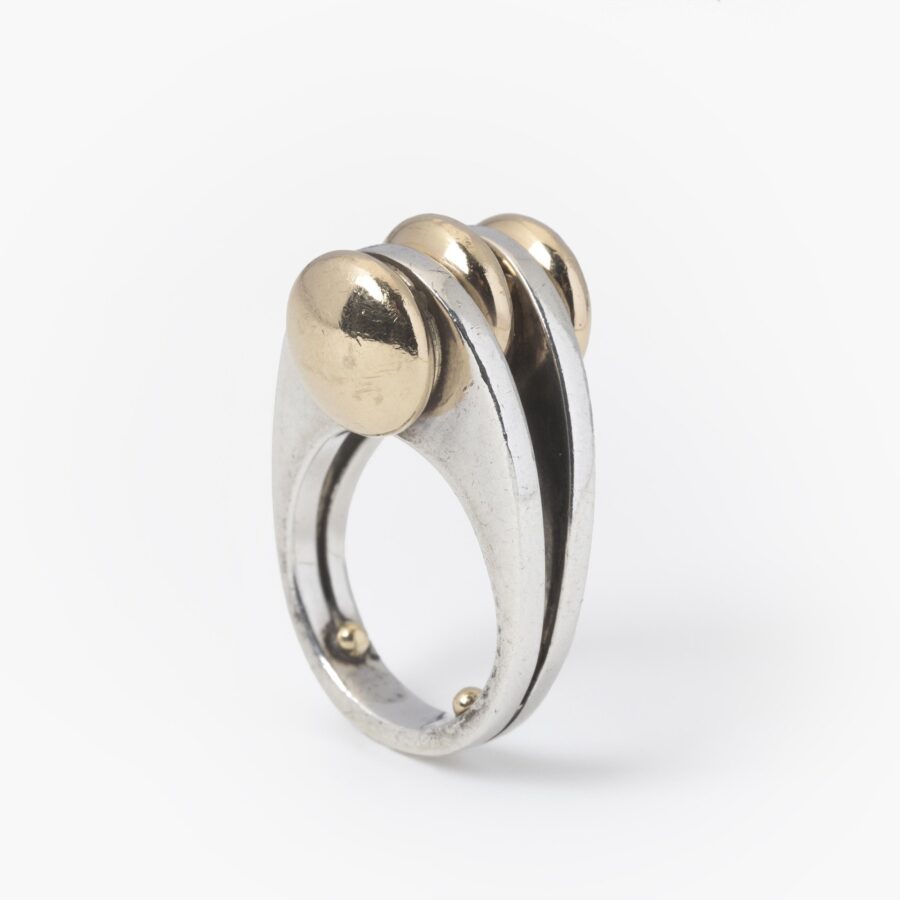 Een eerste gehalte zilveren ring met drie discusvormige veertien karaat geelgouden knoppen. Gesigneerd Pierre Cardin, vervaardigd omstreeks 1965.