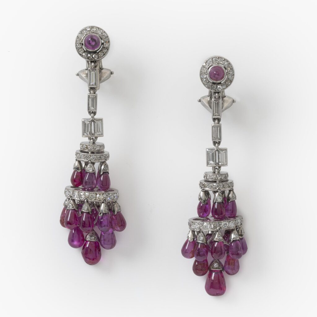Een paar platina Art Deco oorbellen, elk met vele druppelvormige robijnen en diamanten, vervaardigd omstreeks 1920.