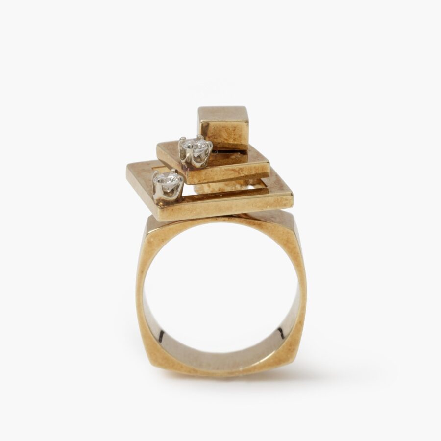 Een veertien karaat geelgouden kinetische ring bestaande uit twee draaiende vierkanten, elk bezet met een diamant. Gesigneerd N. Teufel, USA, 1972.
