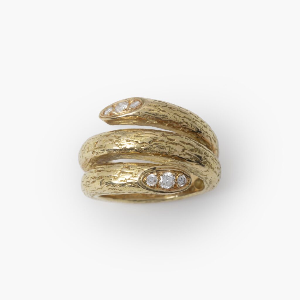 Een achttien karaat geelgouden ring met getextureerd oppervlak, de uiteinden bezet met diamanten. Gesigneerd Van Cleef & Arpels, Parijs, omstreeks 1970.