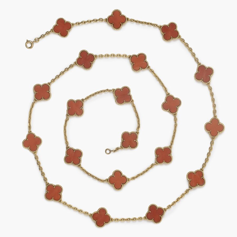 Een achttien karaat geelgouden “Alhambra” sautoir met twintig “Alhambra”-motieven van koraal. Gesigneerd Van Cleef & Arpels, vervaardigd in 1977.