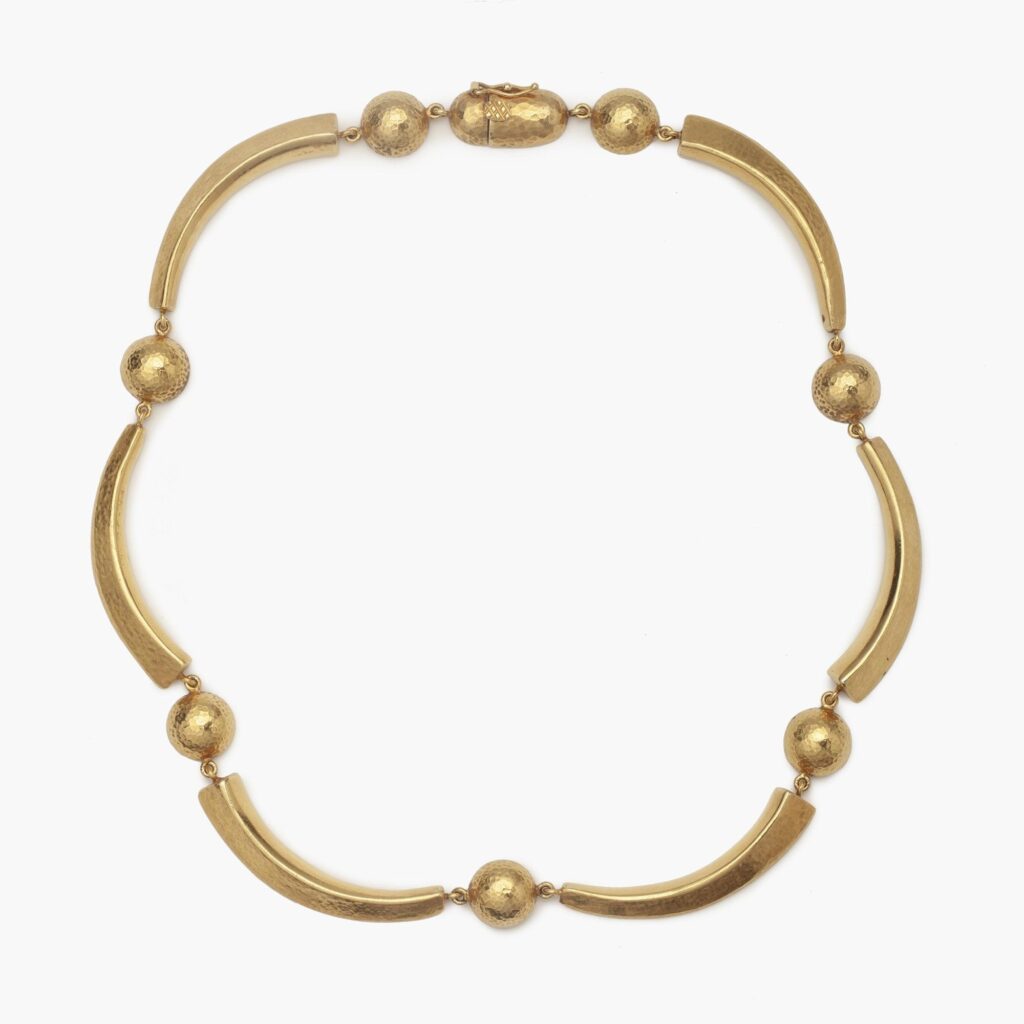 Een achttien karaat geelgouden gehamerd collier bestaande uit maanvormige bogen en halve bollen. Gesigneerd Lalaounis, Athene, Griekenland, omstreeks 1977.