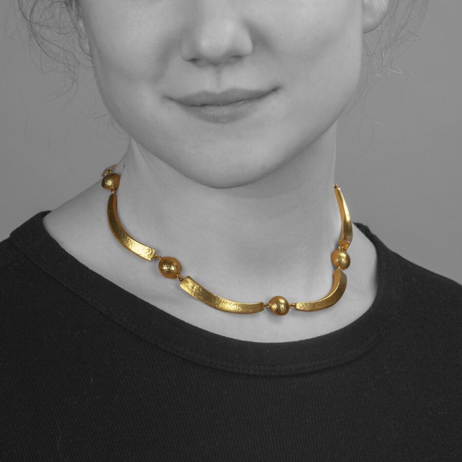 Een achttien karaat geelgouden gehamerd collier bestaande uit maanvormige bogen en halve bollen. Gesigneerd Lalaounis, Athene, Griekenland, omstreeks 1977.