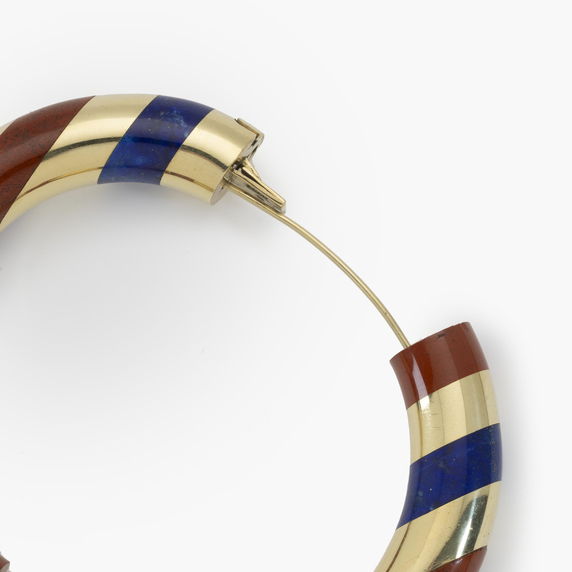 Een achttien karaat geelgouden stijve armband met gesneden lapis lazuli afgewisseld met banden van rode jaspis. Gesigneerd Tiffany & Co., omstreeks 1978.