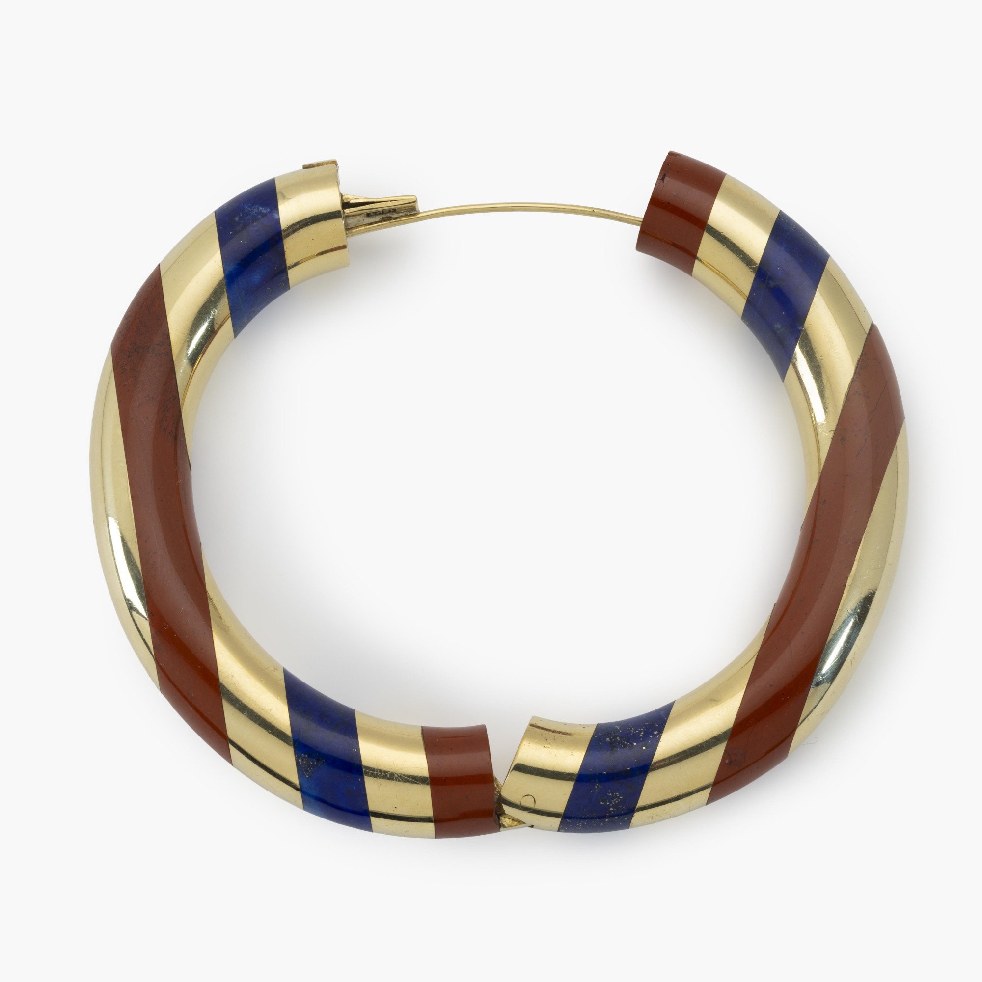 Een achttien karaat geelgouden stijve armband met gesneden lapis lazuli afgewisseld met banden van rode jaspis. Gesigneerd Tiffany & Co., omstreeks 1978.