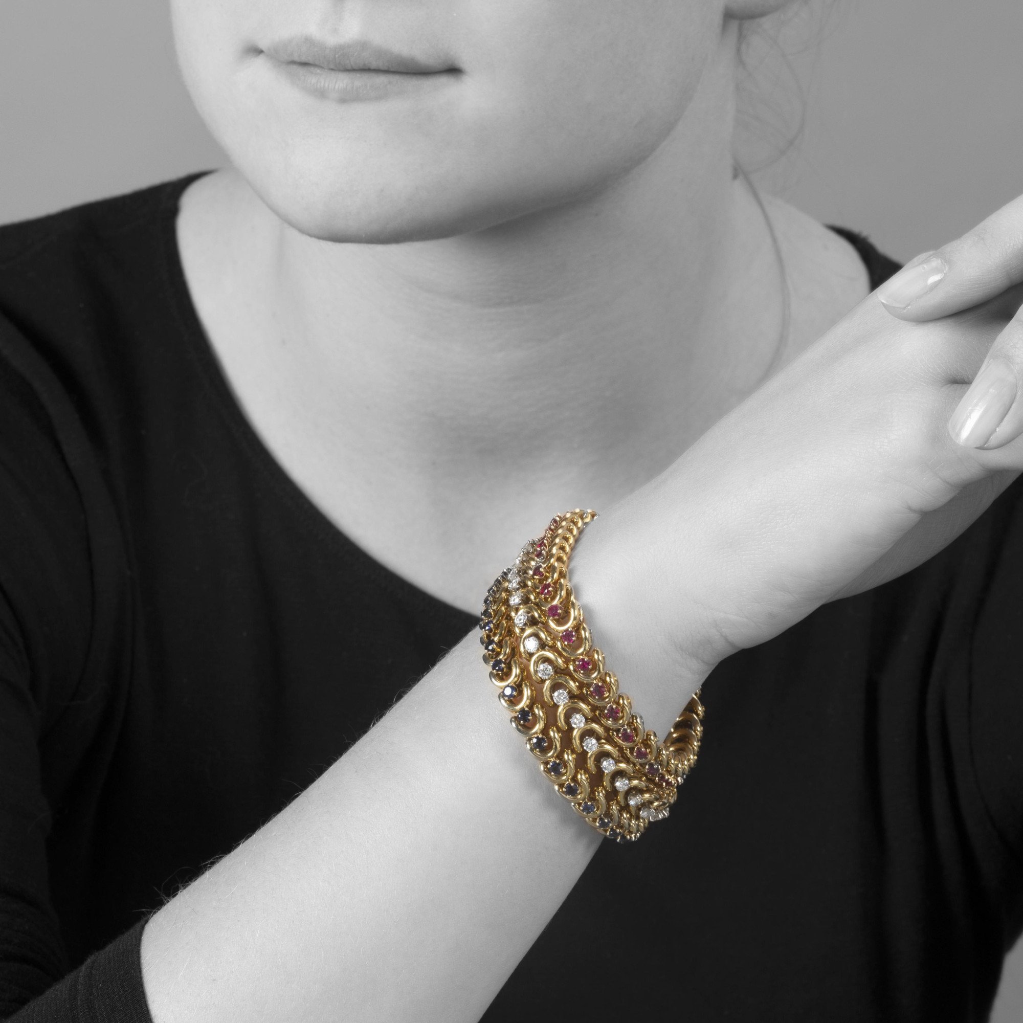 Een set van drie gelijke achttien karaat geelgouden armbanden; bezet met saffier, robijn en diamant. Van Cleef & Arpels, New York, in origineel etui.