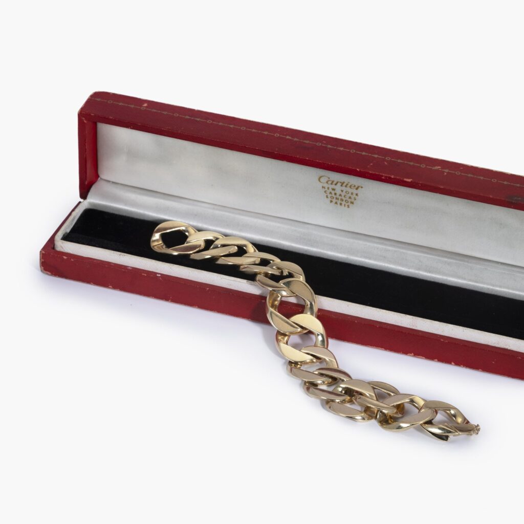 Een veertien karaat geelgouden armband bestaande uit gourmetschakels. Gesigneerd Cartier, vervaardigd in de jaren 50 en genummerd. Met origineel etui.