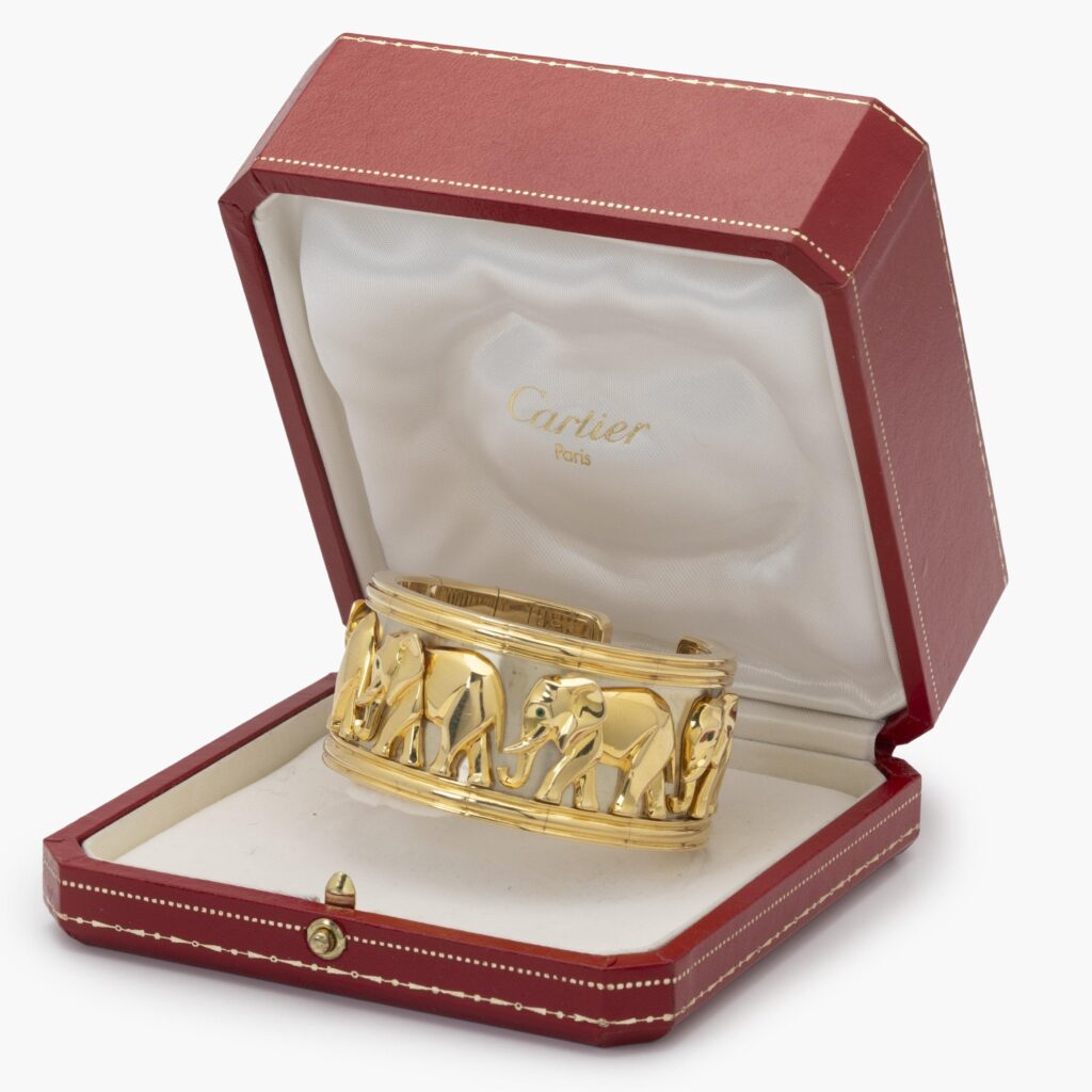 Een achttien karaat geelgouden armband ‘Djigar’ bestaande uit een band van vijf olifanten. Gesigneerd Cartier, Parijs, 1992. In origineel etui.