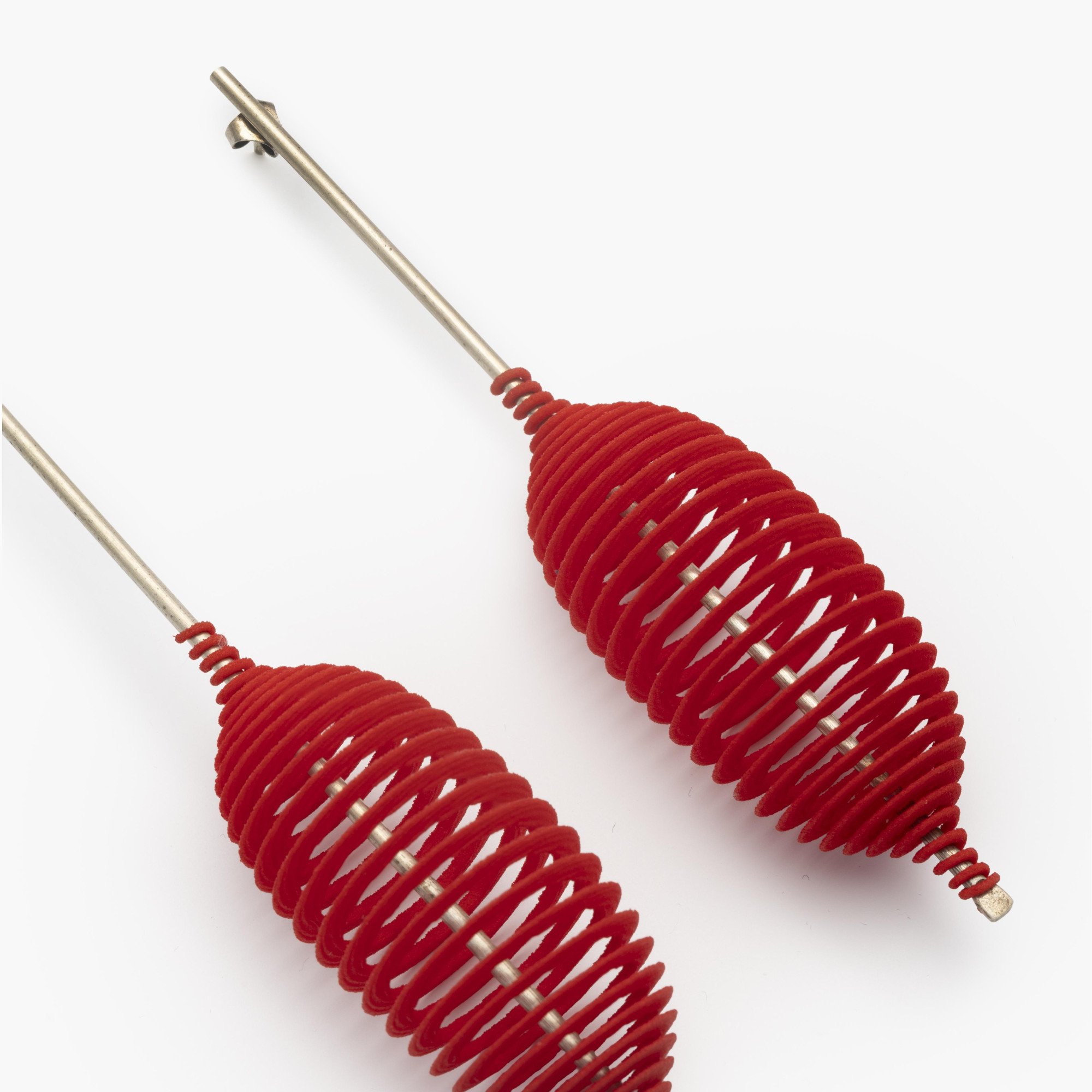 Een paar zilveren ‘Hot Ingo’ oorbellen met rode kunststof spiraal, laser gesneden uit polyamide. Ontwerp Ron Arad, heruitgave uit 2016. In originele doos