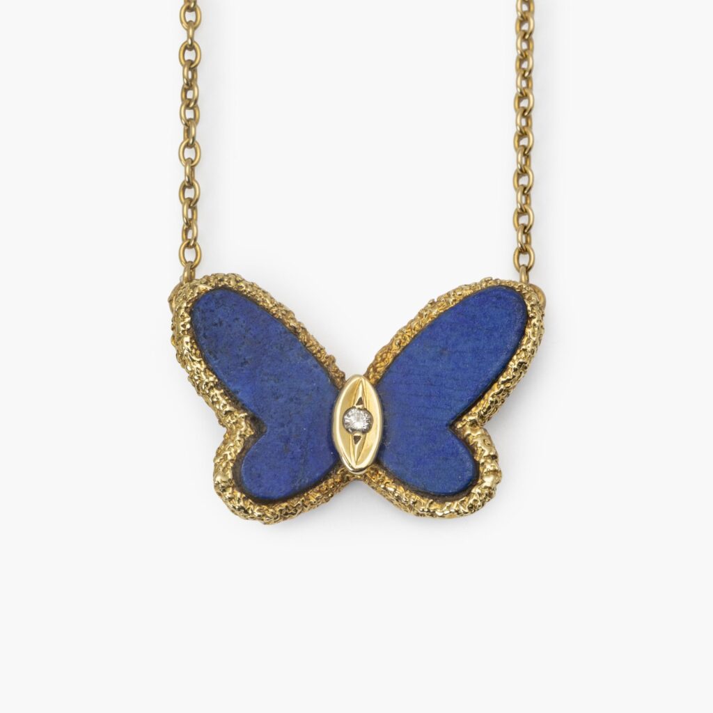 Een achttien karaat geelgouden hanger in de vorm van een vlinder, de vleugels gesneden van lapis lazuli. Gesigneerd Van Cleef & Arpels, Parijs, ca 1970.
