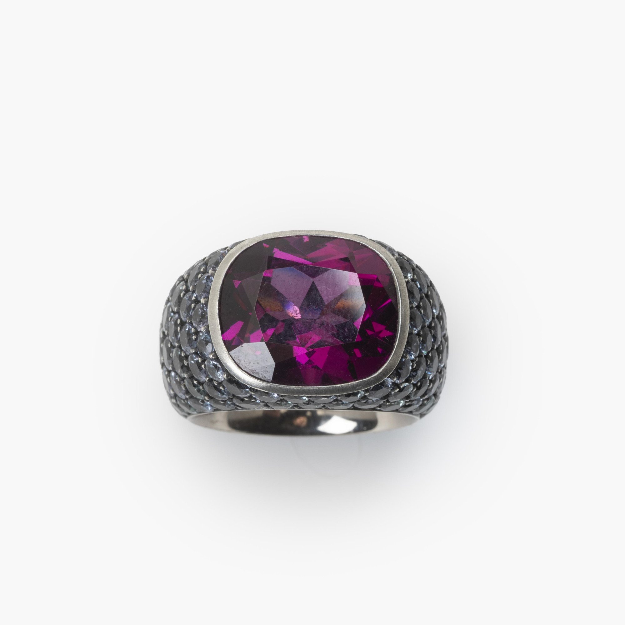 Een achttien karaat witgoud en zilveren ring bezet met een zeldzame paarse granaat en kleine paars-blauwe ‘colour change’ granaten. Hemmerle, München.
