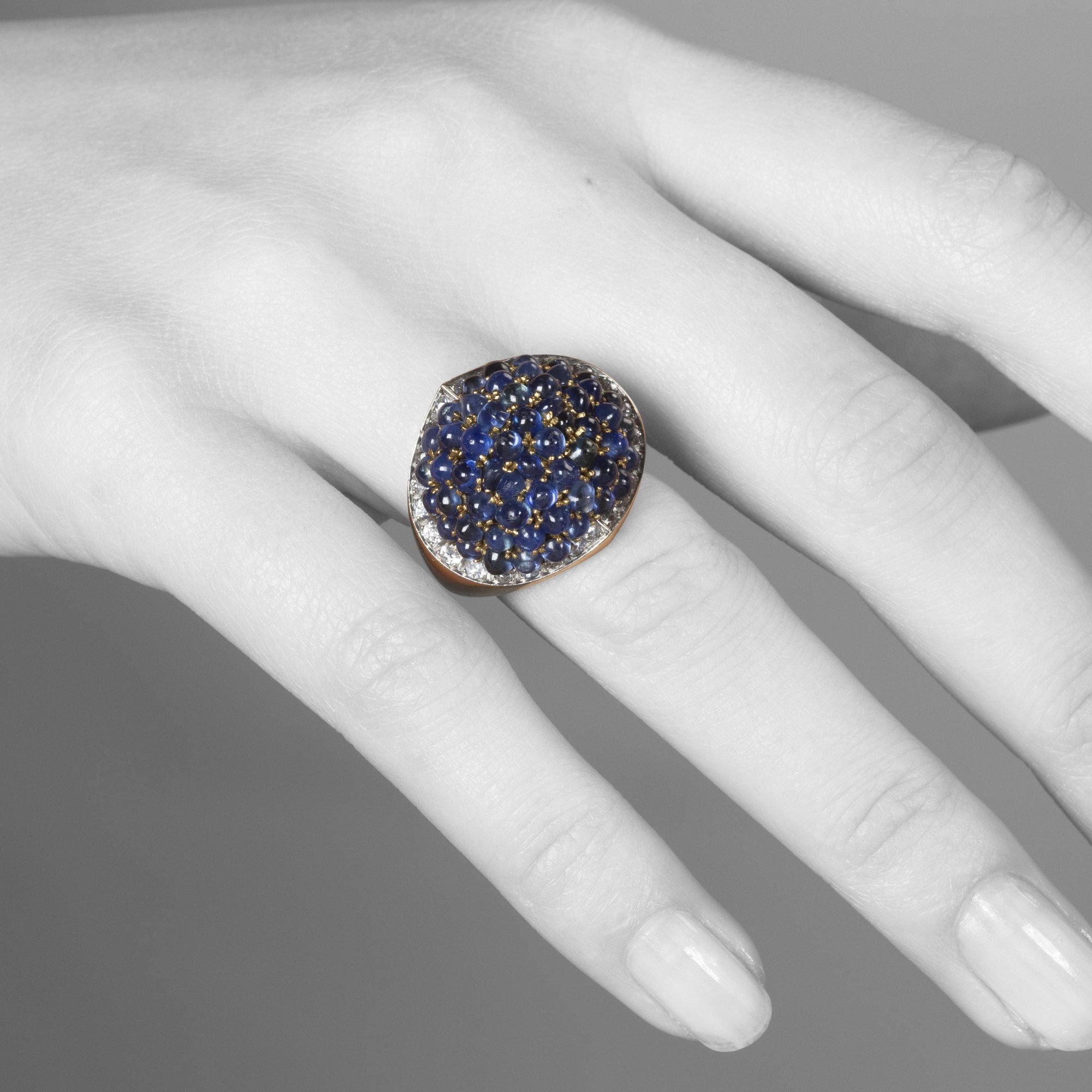 Een achttien karaat geelgoud en platina ring, bezet met cabochon geslepen saffieren en briljant geslepen diamanten. Gesigneerd Van Cleef & Arpels.