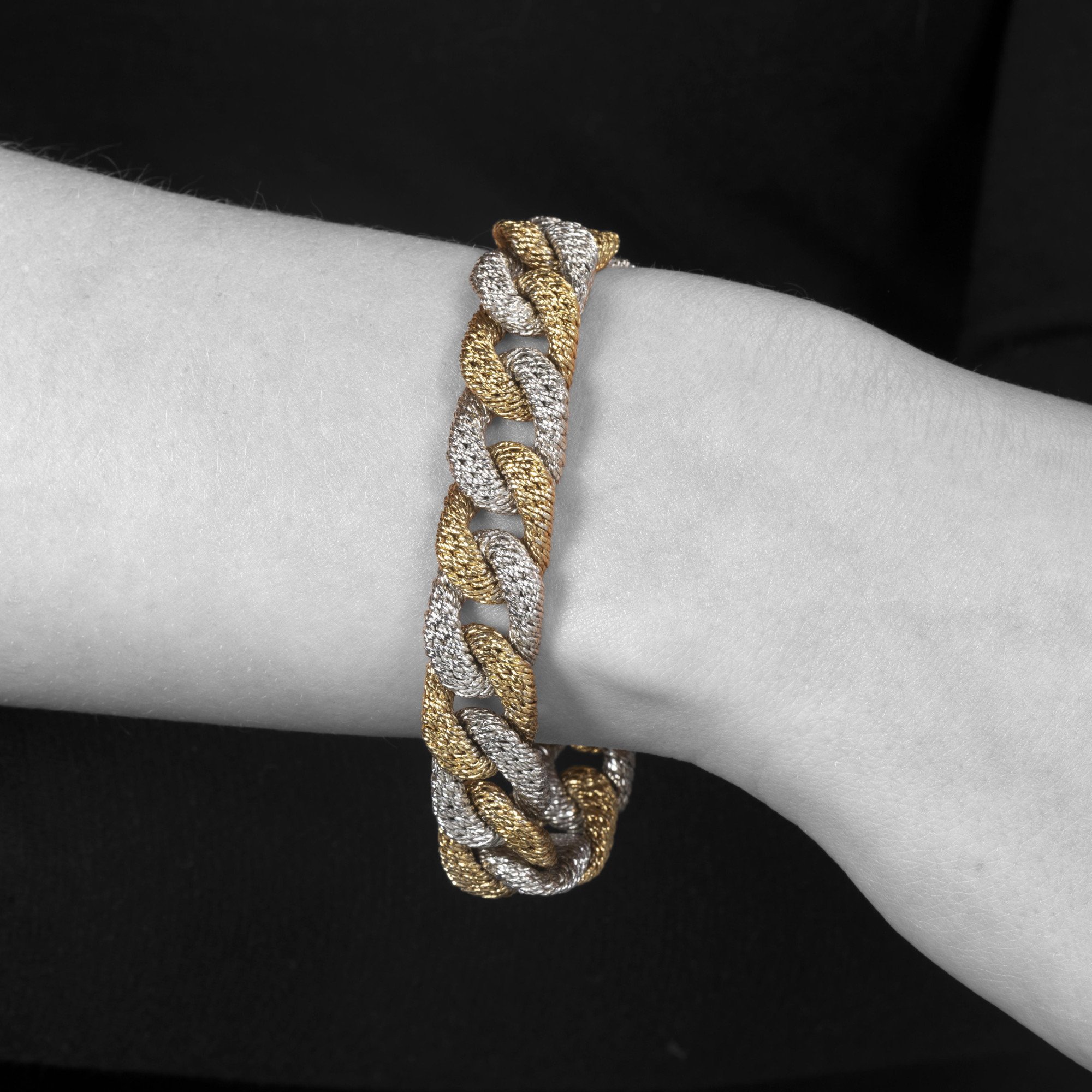 Een achttien karaat wit- en geelgouden gourmet schakelarmband. Met meesterteken van Georges Lenfant, Parijs. Vervaardigd omstreeks 1970.