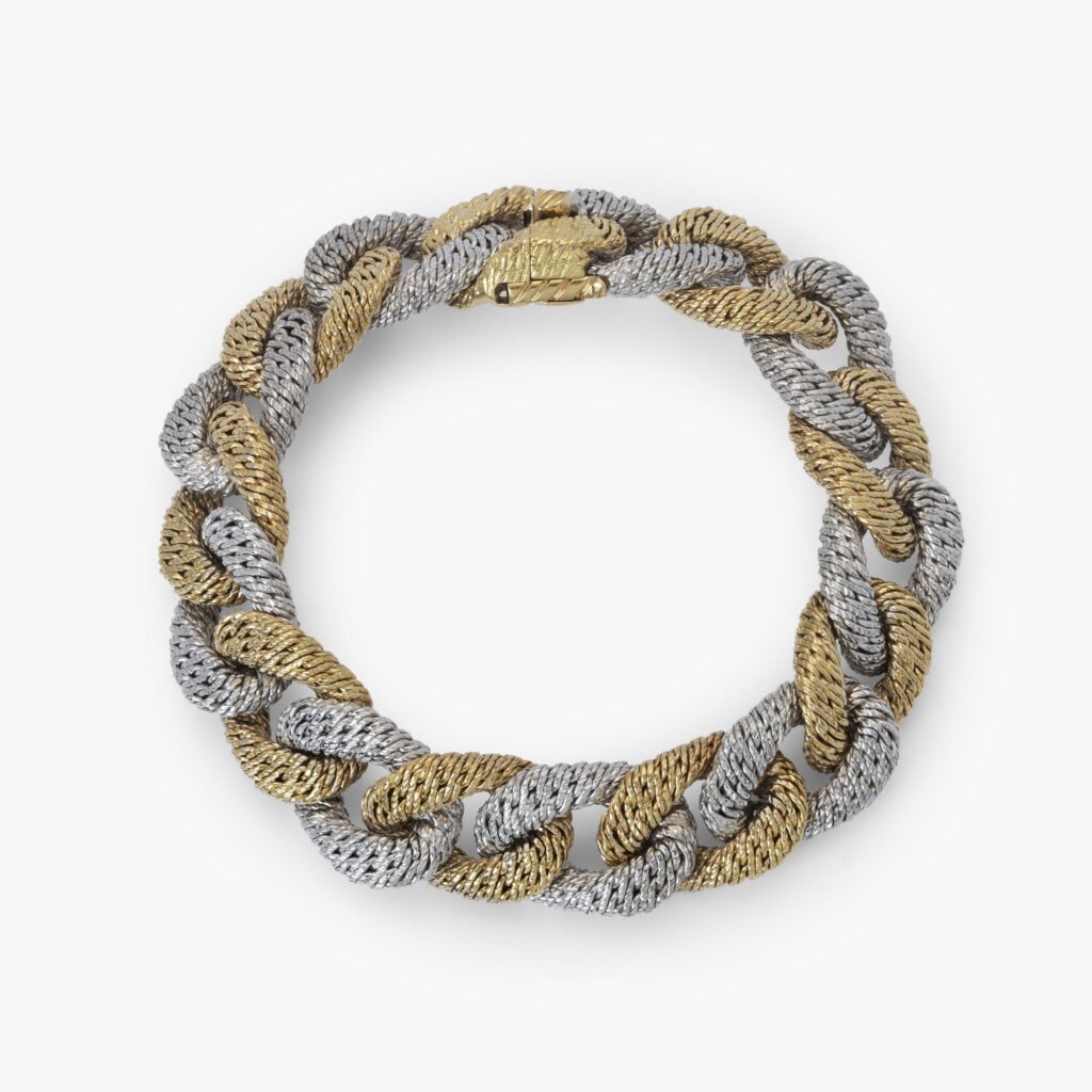 Een achttien karaat wit- en geelgouden gourmet schakelarmband. Met meesterteken van Georges Lenfant, Parijs. Vervaardigd omstreeks 1970.