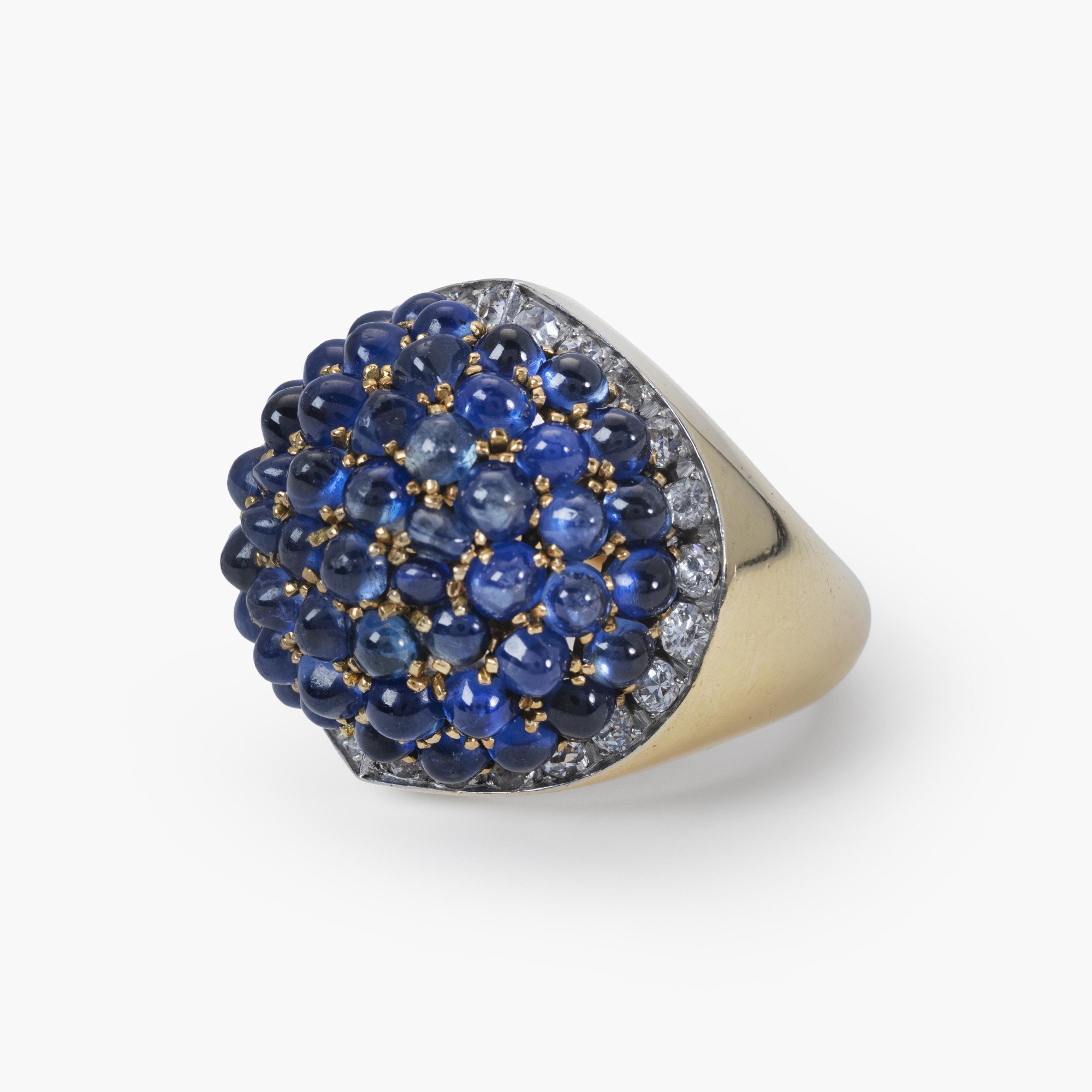 Een achttien karaat geelgoud en platina ring, bezet met cabochon geslepen saffieren en briljant geslepen diamanten. Gesigneerd Van Cleef & Arpels.