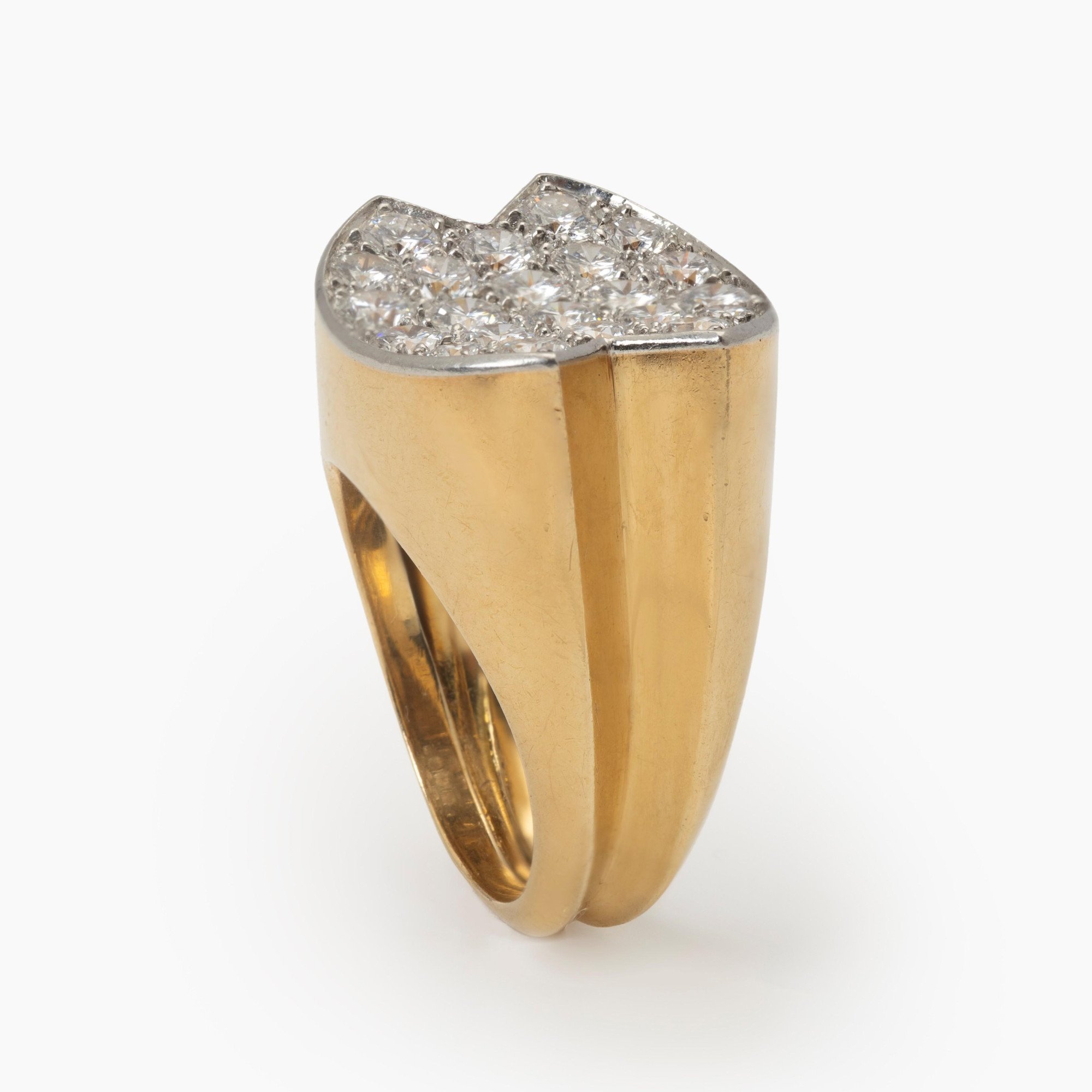 Een achttien karaat geelgouden ring, de bovenzijde van platina bezet met briljant geslepen diamanten. Gesigneerd Cartier Paris en genummerd. Ca. 1960.