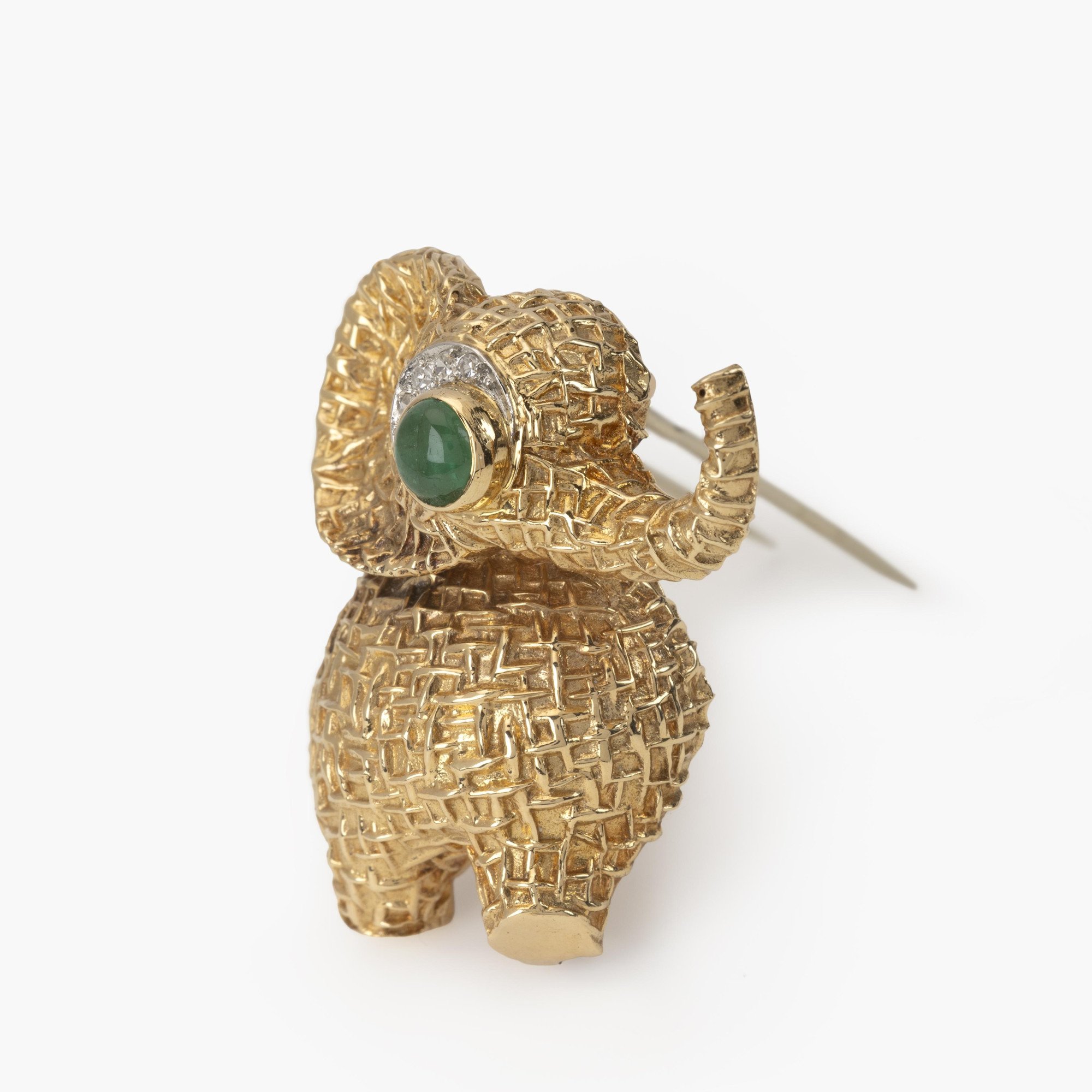 Een achttien karaat geelgouden broche in de vorm van een olifant, het oog bezet met smaragd en diamant. Gesigneerd Van Cleef & Arpels, Parijs, ca 1970.