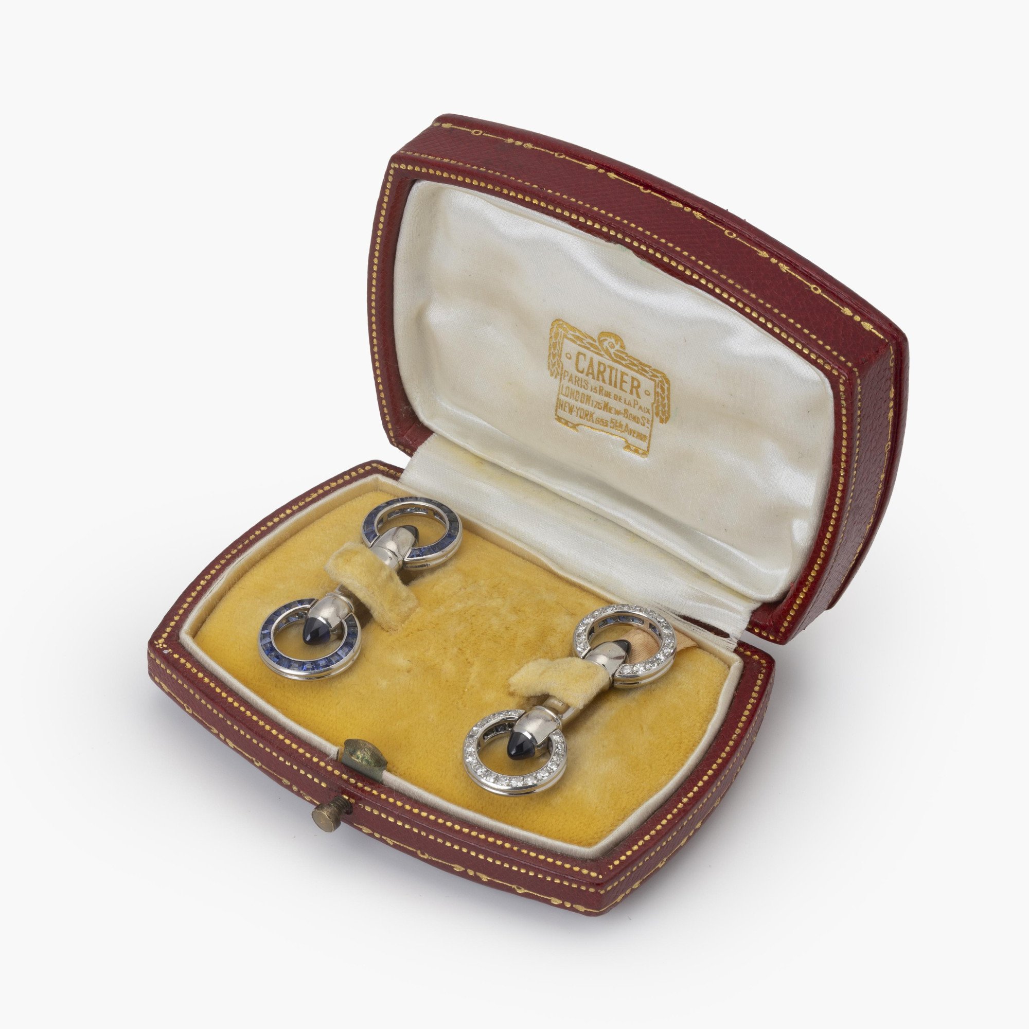 Een paar platina Art Deco manchetknopen bezet met saffieren en diamanten. Gesigneerd Cartier Paris en genummerd. Vervaardigd ca 1925. In origineel etui.