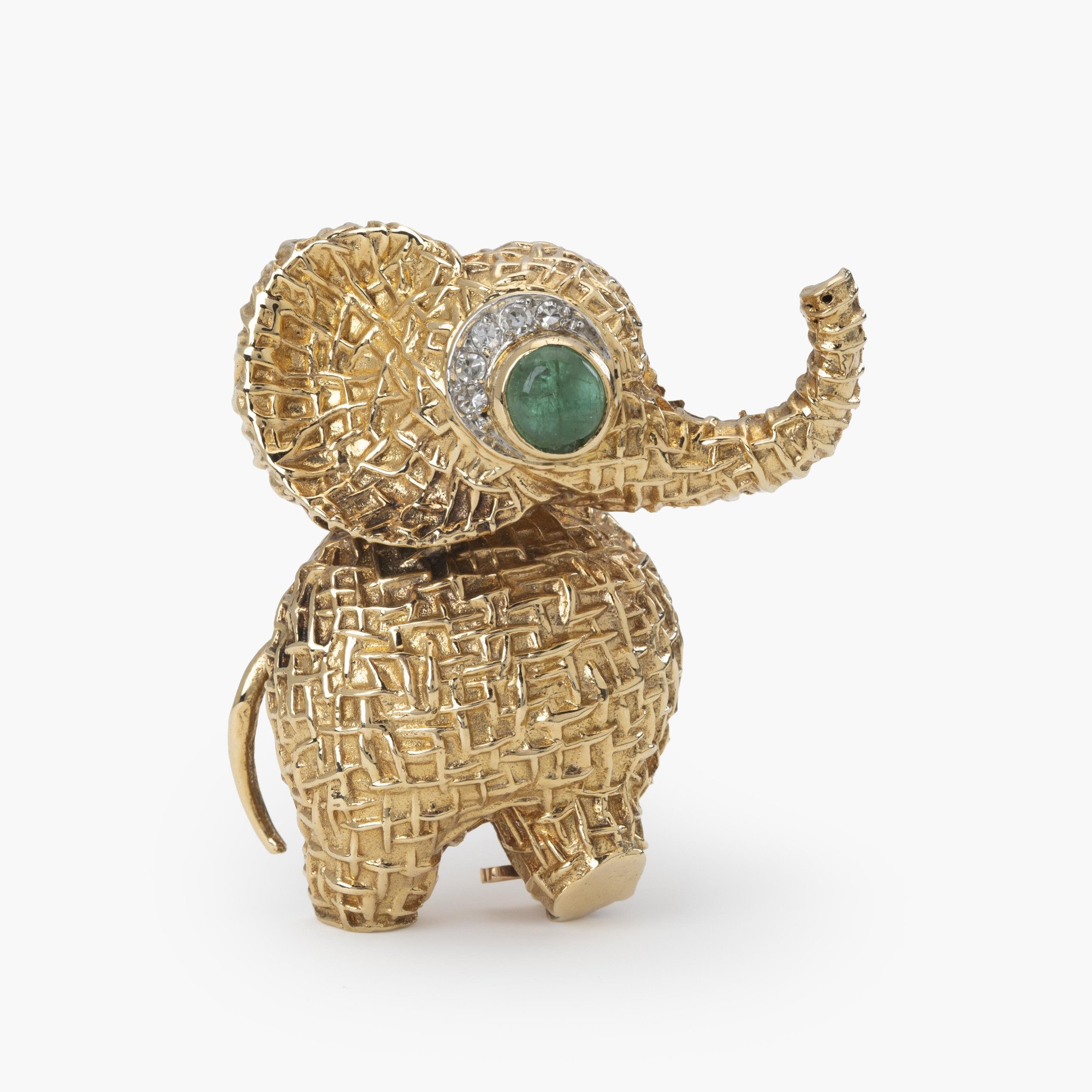 Een achttien karaat geelgouden broche in de vorm van een olifant, het oog bezet met smaragd en diamant. Gesigneerd Van Cleef & Arpels, Parijs, ca 1970.