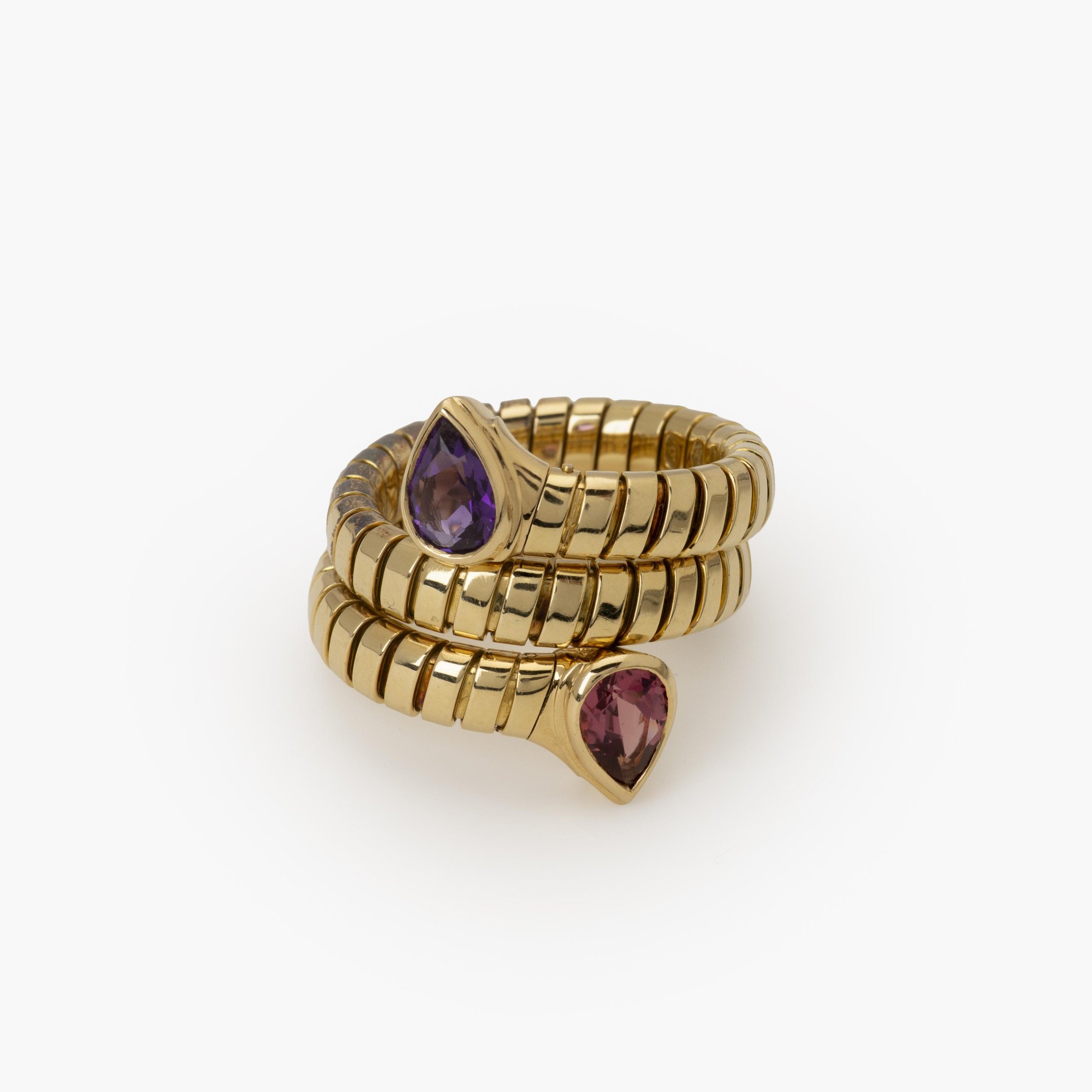 Een achttien karaat geelgouden flexibele ‘Tubogas’ ring bezet met amethist en toermalijn. Gesigneerd Bvlgari, Italië. Met originele aankoopbon uit 1996.