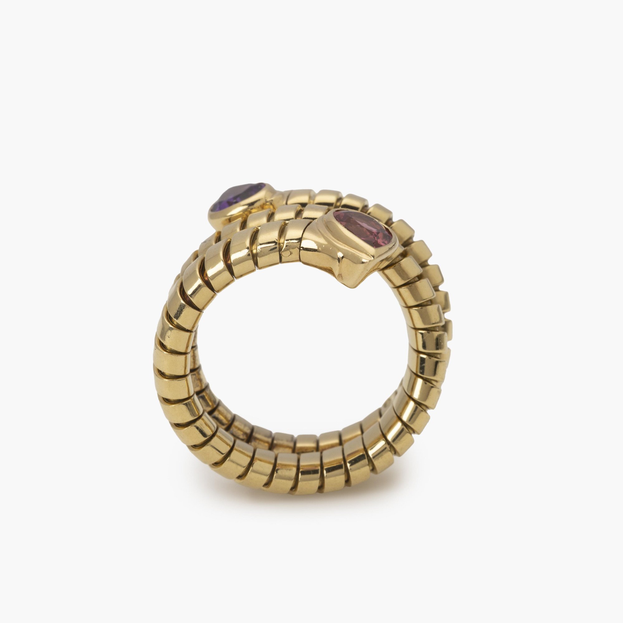 Een achttien karaat geelgouden flexibele ‘Tubogas’ ring bezet met amethist en toermalijn. Gesigneerd Bvlgari, Italië. Met originele aankoopbon uit 1996.