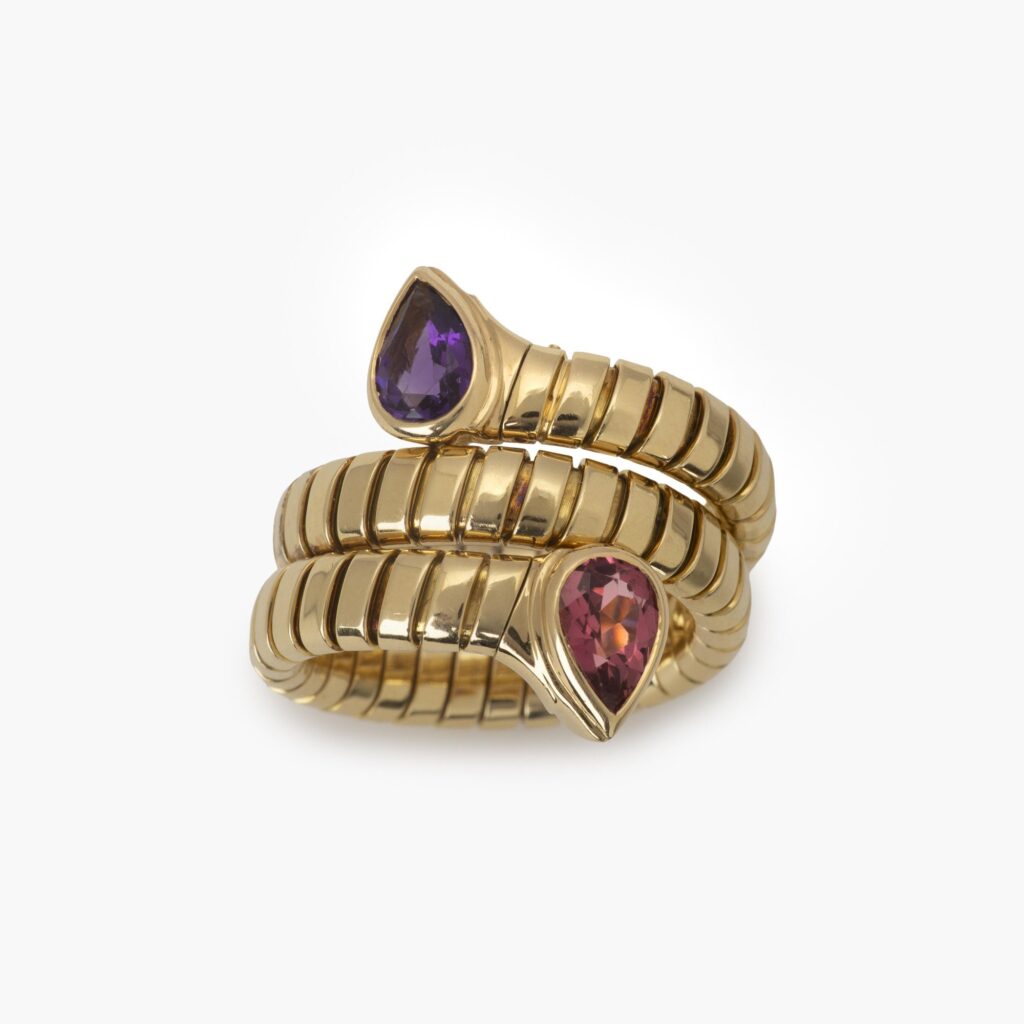 Een achttien karaat geelgouden flexibele ‘Tubogas’ ring bezet met amethist en toermalijn. Gesigneerd Bvlgari, Italië. Met originele aankoopbon uit 1996.