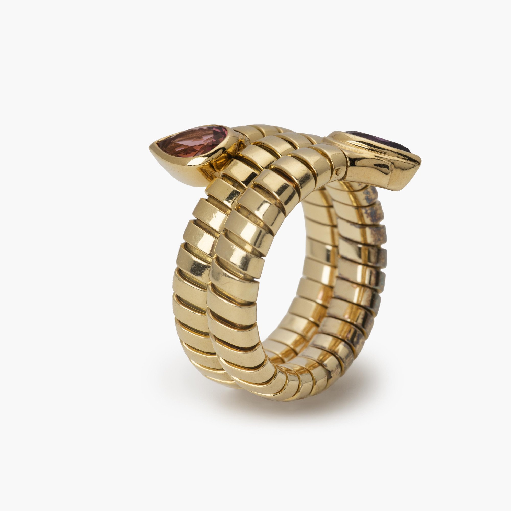 Een achttien karaat geelgouden flexibele ‘Tubogas’ ring bezet met amethist en toermalijn. Gesigneerd Bvlgari, Italië. Met originele aankoopbon uit 1996.