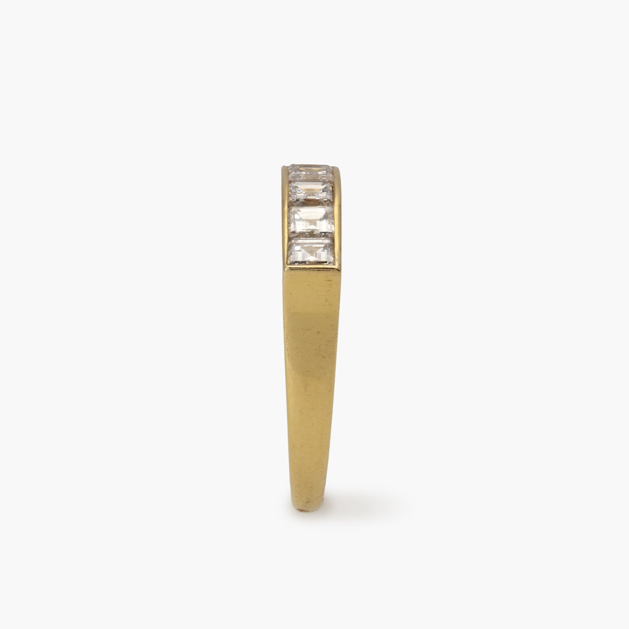 Een achttien karaat geelgouden rechte rijring, in railzetting bezet met zeven carré geslepen diamanten. Gesigneerd Cartier Paris en genummerd.