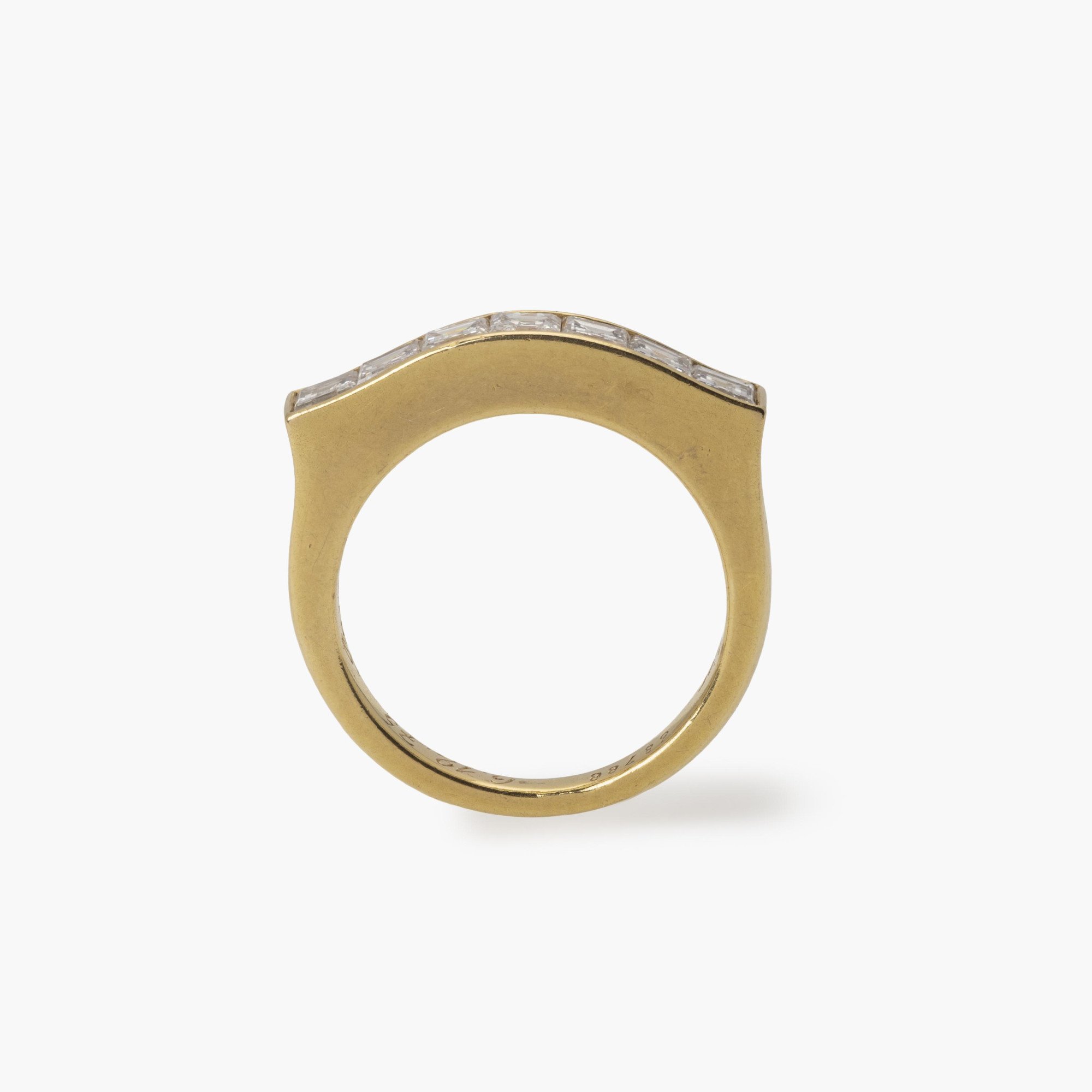 Een achttien karaat geelgouden rechte rijring, in railzetting bezet met zeven carré geslepen diamanten. Gesigneerd Cartier Paris en genummerd.