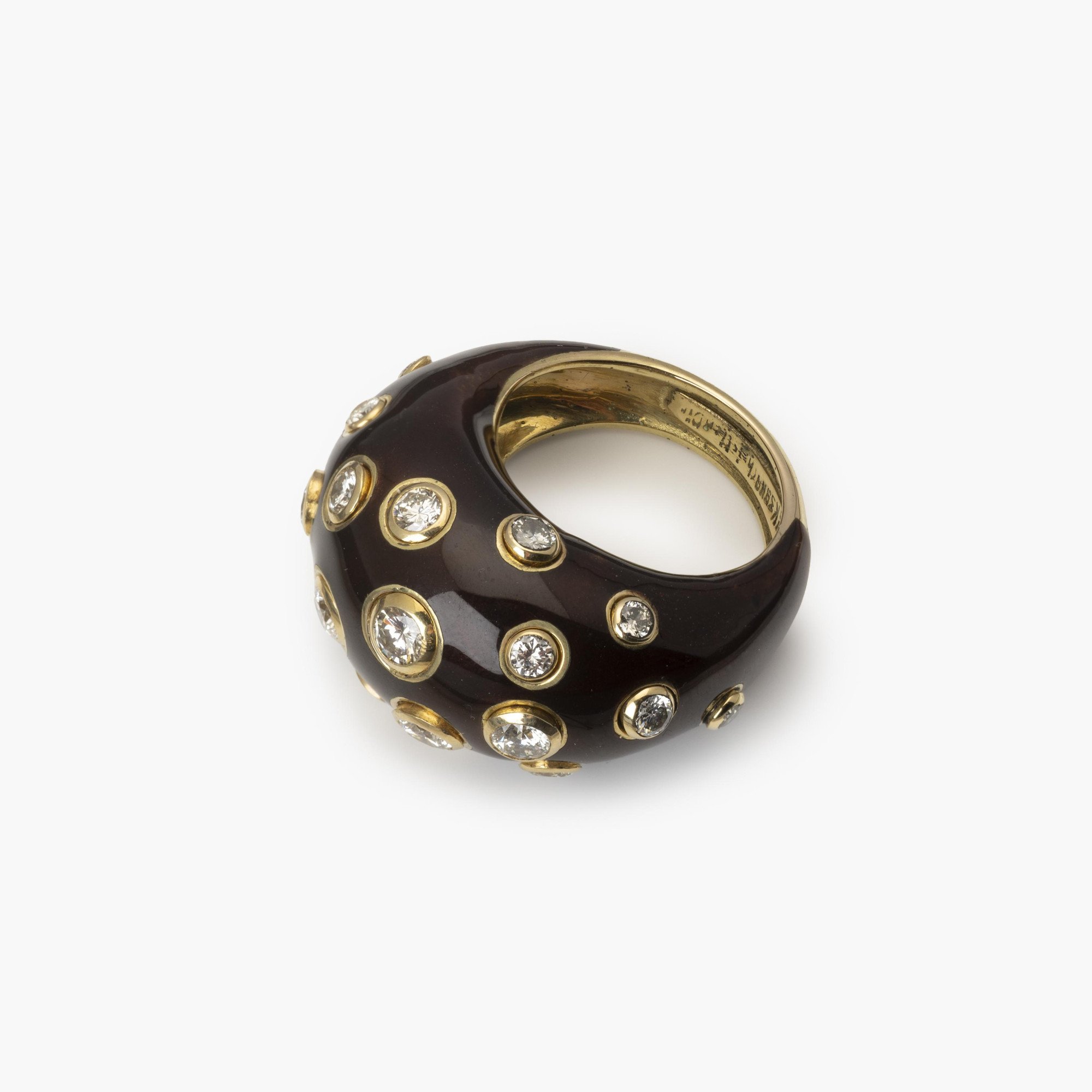 Een achttien karaat geelgouden bolle ring, met bruin emaille en briljant geslepen diamant. Gesigneerd Christian Dior, vervaardigd omstreeks 1980.